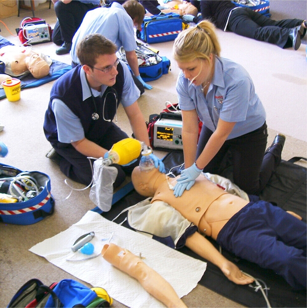 Healthcare professional performing chest compressions on a CPR training mannequin, demonstrating proper hand positioning and technique